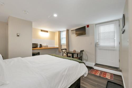 a bedroom with a large white bed and a kitchen at The Inn & More in Bartlett