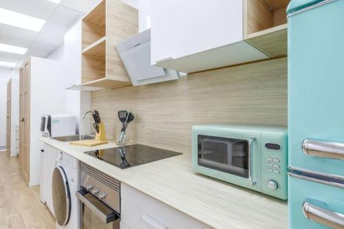 a kitchen with a blue microwave on a counter at Acogedor estudio en el Centro de Valencia in Valencia