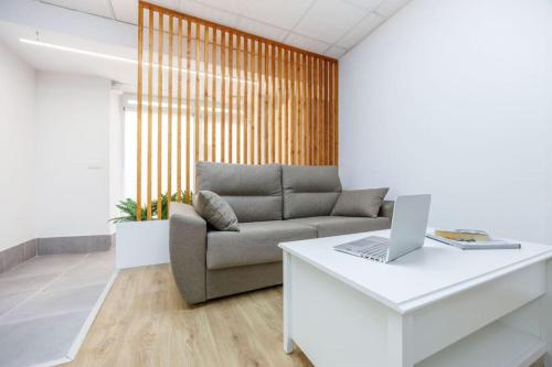 a living room with a couch and a laptop on a table at Acogedor estudio en el Centro de Valencia in Valencia