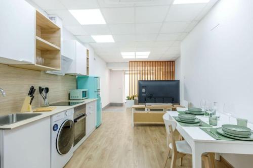 a kitchen with a table and a washing machine at Acogedor estudio en el Centro de Valencia in Valencia