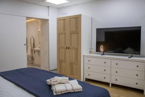 a bedroom with a bed with a tv and a dresser at Acogedor estudio en el Centro de Valencia in Valencia