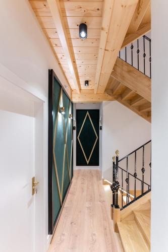 a hallway with a wooden ceiling and a staircase at Hostal HCELENIS in Caldas de Reis