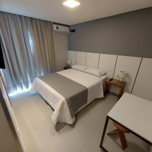 a bedroom with a white bed and a window at Pousada Infinity Gasthaus in Pomerode