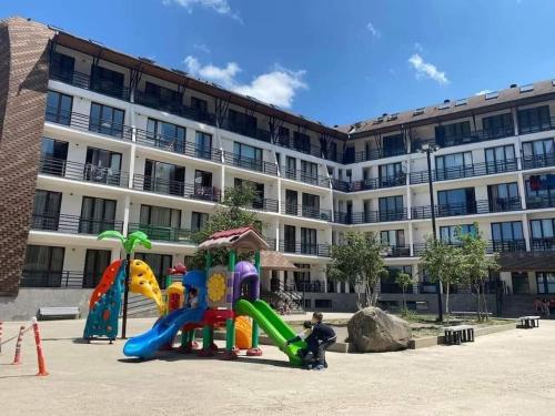 a group of playground equipment in front of a building at Bakuriani Haystack Apartment 219 Rooftop Views in Bakuriani