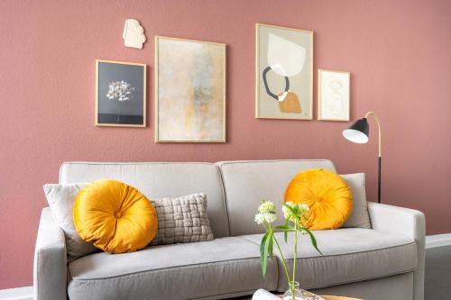 フリードリヒスハーフェンにあるBodenseeApartment Kammerのリビングルーム(オレンジ色の枕とグレーのソファ付)