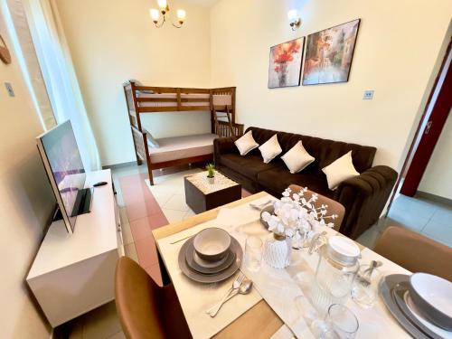 a living room with a table and a couch at Cozy 1 Bedroom apartment in Dubai by Al Ghaimah Holiday Homes in Dubai