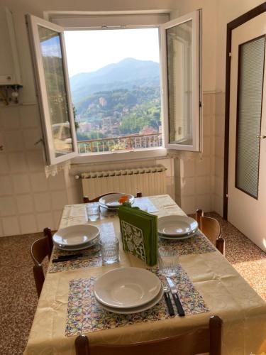 a table with a view of a mountain from a window at Casa Maria in Serra Riccò