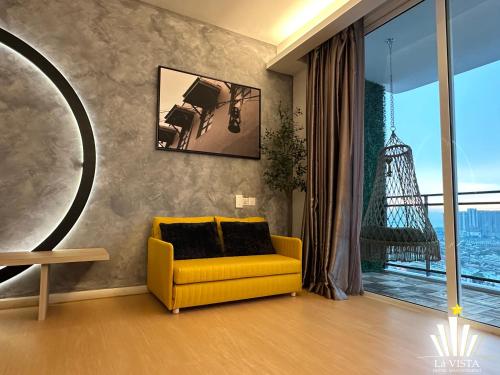 a living room with a yellow couch and a window at The Shore Hotel & Residences By Lá VISTA in Melaka