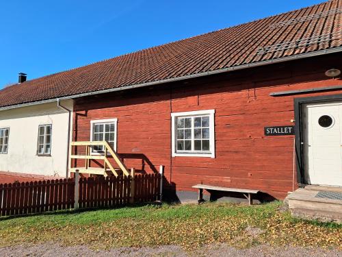 a red building with a wooden fence in front of it at Furudals Bruk in Furudals Bruk