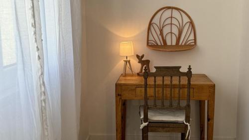a wooden table with a lamp and a chair at Le Clos Du Moulin 3, villa jardin, 3 chambres, près d'Avignon en Provence in Entraigues-sur-la-Sorgue