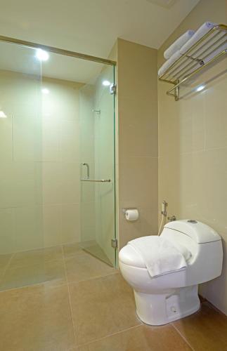 a bathroom with a toilet and a glass shower at D'Kalpa Hotel Demangan Yogyakarta in Yogyakarta