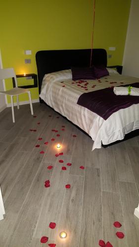 a room with a bed with red rose petals on the floor at La Lira in Fiumicino