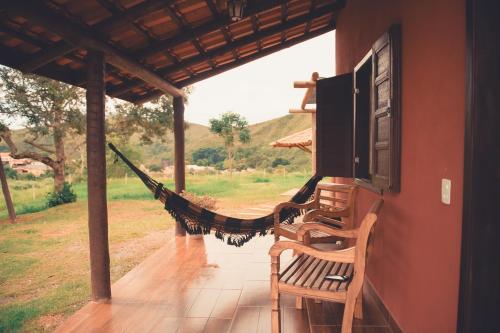 a hammock on the porch of a house at Pousada Chalés do Rancho Canastra in Vargem Bonita