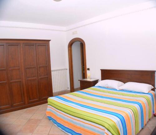 a bedroom with a bed with a colorful striped blanket at Agriturismo sul Sentiero in Pianillo