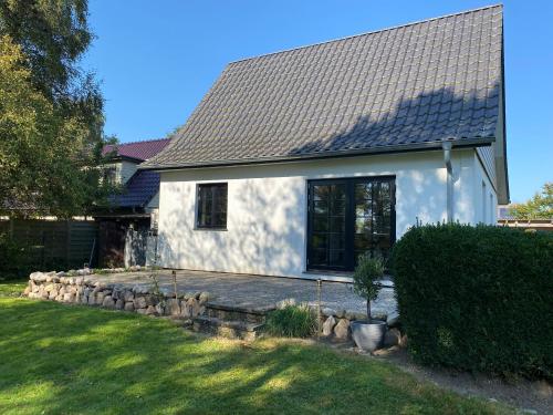 a white house with a stone bench in front of it at Ferienhaus im Treenetal - zwischen Nordsee und Ostsee in Treia