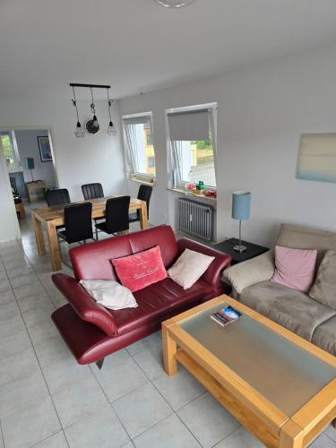 Una sala de estar con un sofá rojo y una mesa. en TBM-Haus, en Homburg