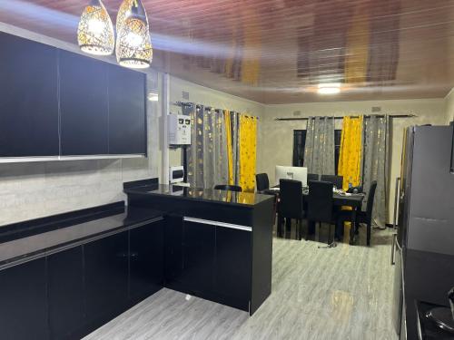 a kitchen and dining room with a table and chairs at Steady State Apartment 5 in Lusaka
