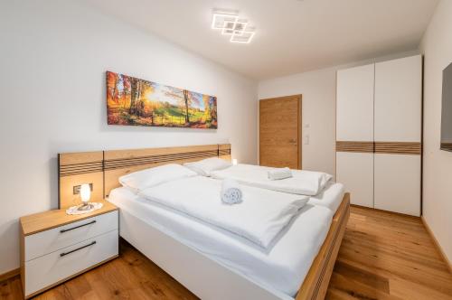 a bedroom with a large white bed with a wooden headboard at Garden AlpinApartment - by myNests in Assach