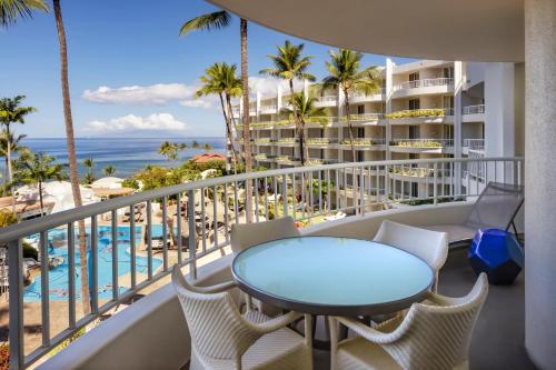 a balcony with a table and chairs and a view of the ocean at Fairmont Kea Lani, Maui in Wailea