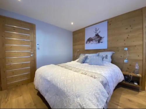 - une chambre avec un lit et un mur en bois dans l'établissement Chalet Solie, à La Bresse