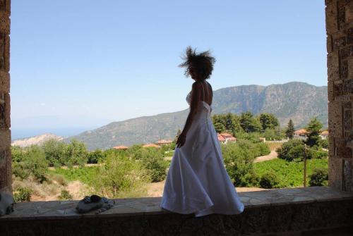 a woman in a wedding dress standing on a ledge at Anta's bnb in Ambelókipoi