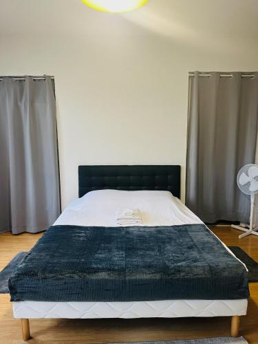 - une chambre avec un lit doté d'une tête de lit et de rideaux noirs dans l'établissement Studio 6 Proche Centre Ville avec Wifi Parking Troyes, à Troyes