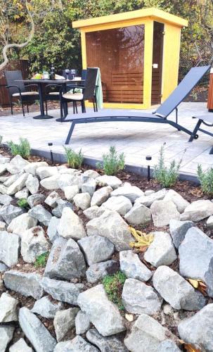 a patio with a stone wall and a building at Panoráma Vendégház in Tahitótfalu