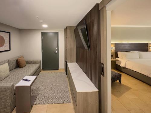 a hotel room with a bed and a couch at Holiday Inn Express Mérida by IHG in Mérida