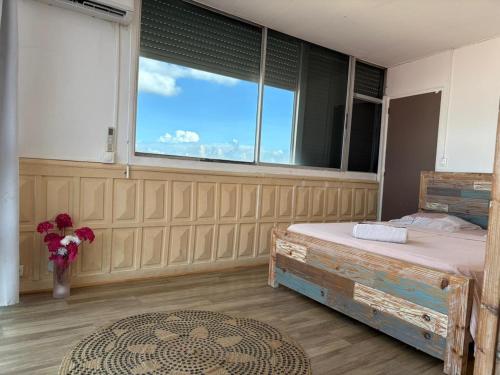 a bedroom with a bed and a large window at PENTHOUSE 10 MIN port croisière et aéroport in Pointe-à-Pitre