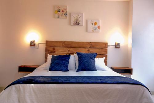 une chambre avec un grand lit avec des oreillers bleus dans l'établissement ALOJARTE RIONEGRO - Acogedor estudio - ubicación privilegiada, à Rionegro