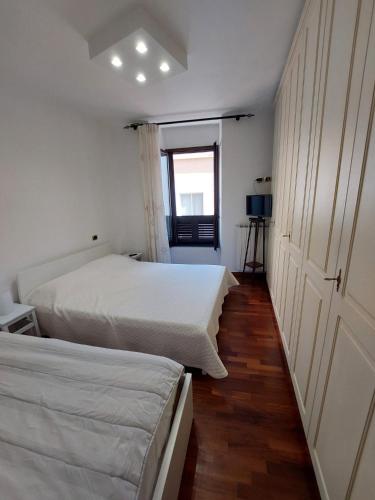 two beds in a small room with a window at Tina's House in Barletta