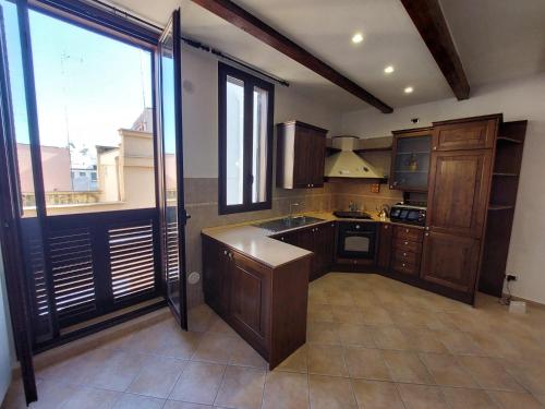 a kitchen with wooden cabinets and a large window at Tina's House in Barletta