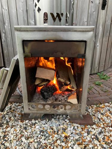 a fire in a stone fireplace on a patio at Bed & Breakfast Hoeve Happiness - ontbijt inbegrepen - wellness aanwezig in Voorthuizen