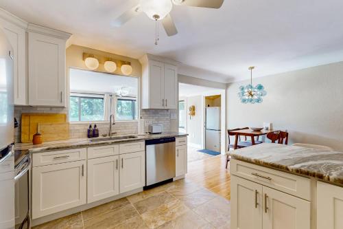 a kitchen with white cabinets and a dining room at Mount Dorable in Mount Dora