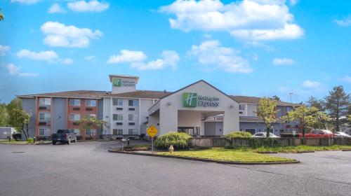 a hotel in a parking lot with a building at Holiday Inn Express Portland East - Columbia Gorge by IHG in Troutdale
