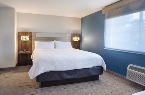 a bedroom with a large bed and a large window at Holiday Inn Express Portland East - Columbia Gorge by IHG in Troutdale