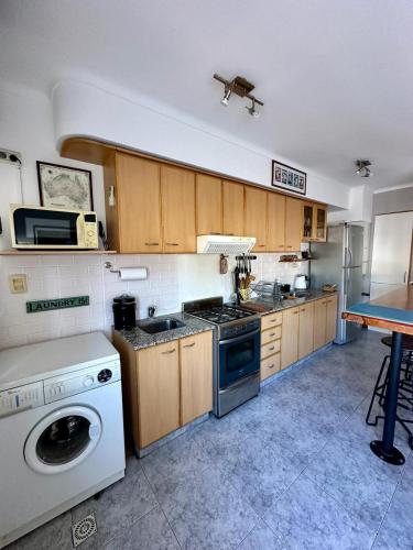 a kitchen with a stove and a washing machine at Hermoso y Confortable Depto in Mendoza
