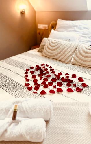 a bunch of red roses on a bed at Apartament z sauną i jacuzzi na wyłączność - Sikorówka - Dobre Miejsce in Wisła