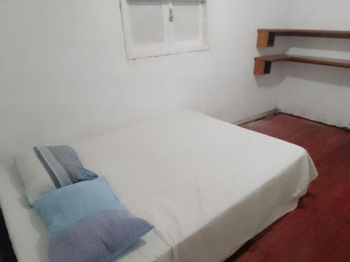 a white bed in a room with a window at Se sinta em casa nessas férias in Igrejinha