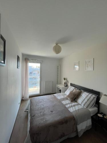 une chambre avec un grand lit et une fenêtre dans l'établissement Bel appartement à Bordeaux Lac, à Bordeaux