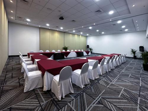 a conference room with a long table and white chairs at Holiday Inn Express Mérida by IHG in Mérida