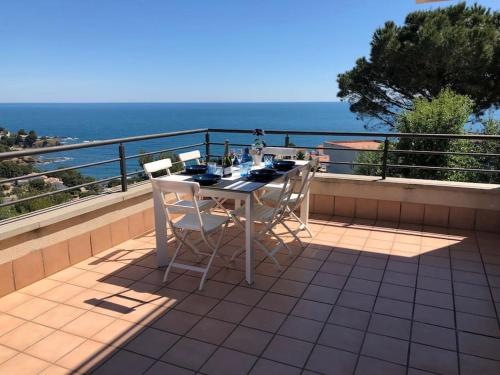 a table and chairs on a balcony overlooking the ocean at Sensational Apartment with panoramic views in Llança