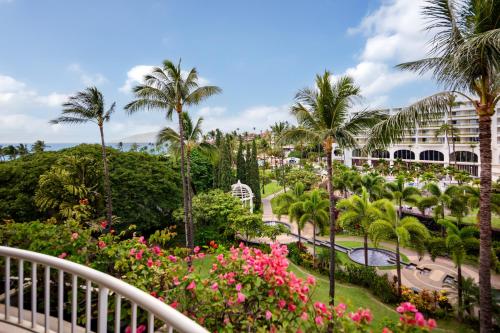 a view from the balcony of a resort with palm trees and flowers at Fairmont Kea Lani, Maui in Wailea
