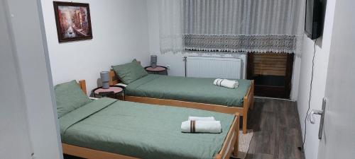 a small room with two beds and a window at Apartman Aleksic in Jagodina