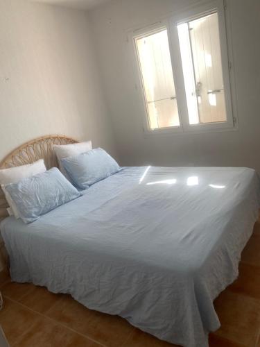 une chambre avec un grand lit blanc avec une fenêtre dans l'établissement Casa coco, à Cavalaire-sur-Mer