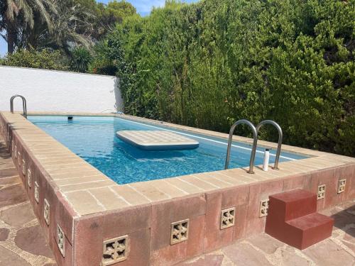 a swimming pool in a brick retaining wall with a poolvisorangering at Casa familiar en la maravillosa ciudad de L'Eliana con 3 habitaciones in La Eliana
