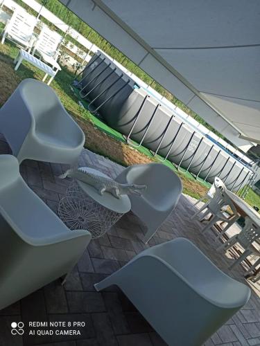 a group of chairs sitting on a patio with an umbrella at Kurt e famiglia in Casalzuigno