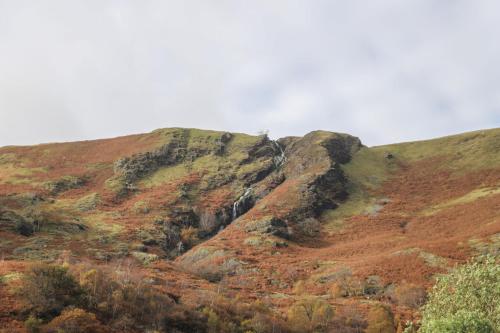 a mountain with a waterfall on the side of it at Ty Nant Cafn in Machynlleth
