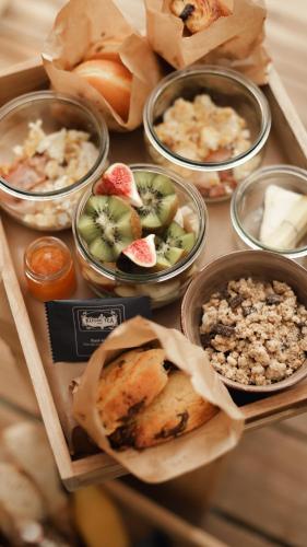 a table topped with different types of food in bowls at Madame Imagine, Lodges & SPA Epinal in Épinal