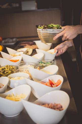 a group of bowls filled with different types of food at Hotel inn Design Laval in Laval
